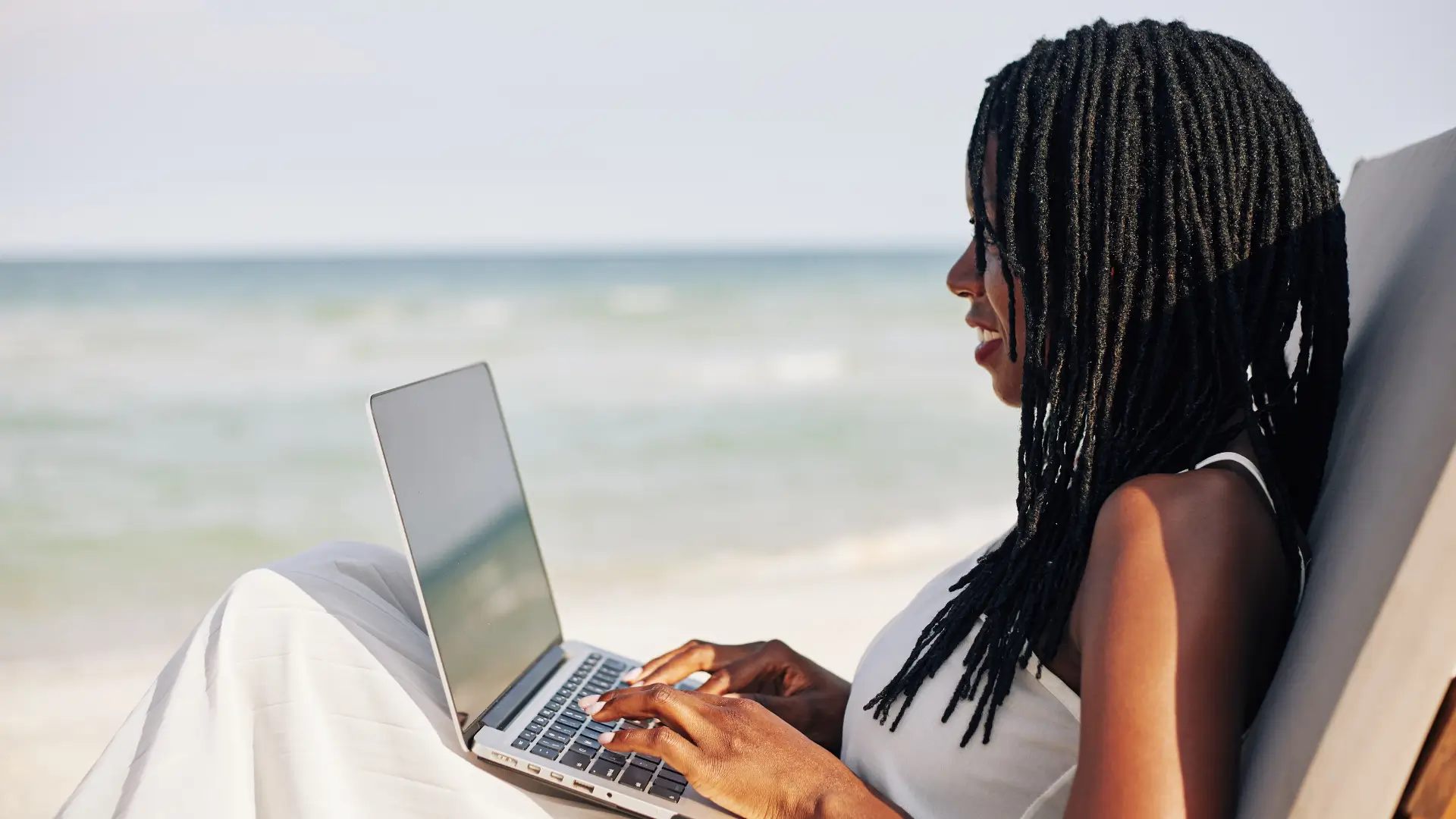 Profissional trabalhando remotamente em frente ao mar, representando o conceito de cultura organizacional em times remotos