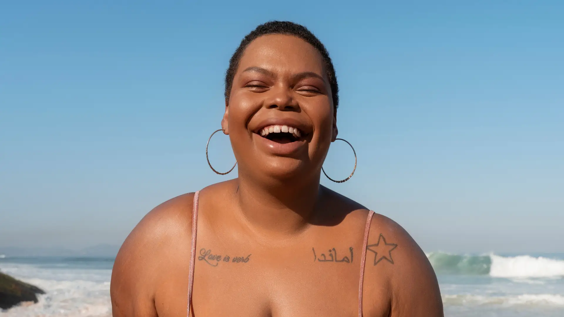 Mulher sorrindo na praia, representando autenticidade e inteligência emocional – duas soft skills essenciais em tempos de inteligência artificial