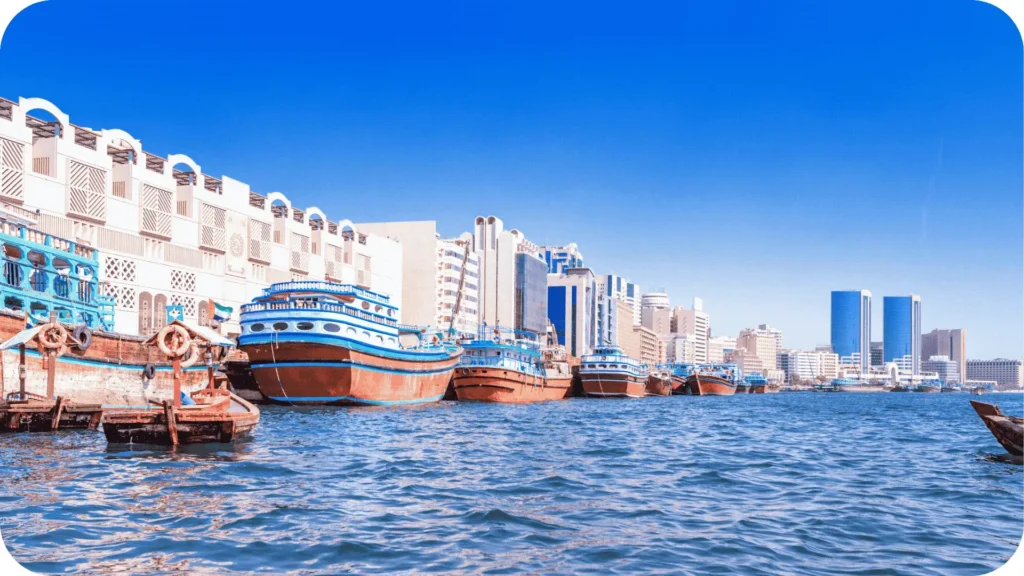 Dubai Creek em destaque, com barcos típicos cruzando o canal que conecta o passado comercial da cidade