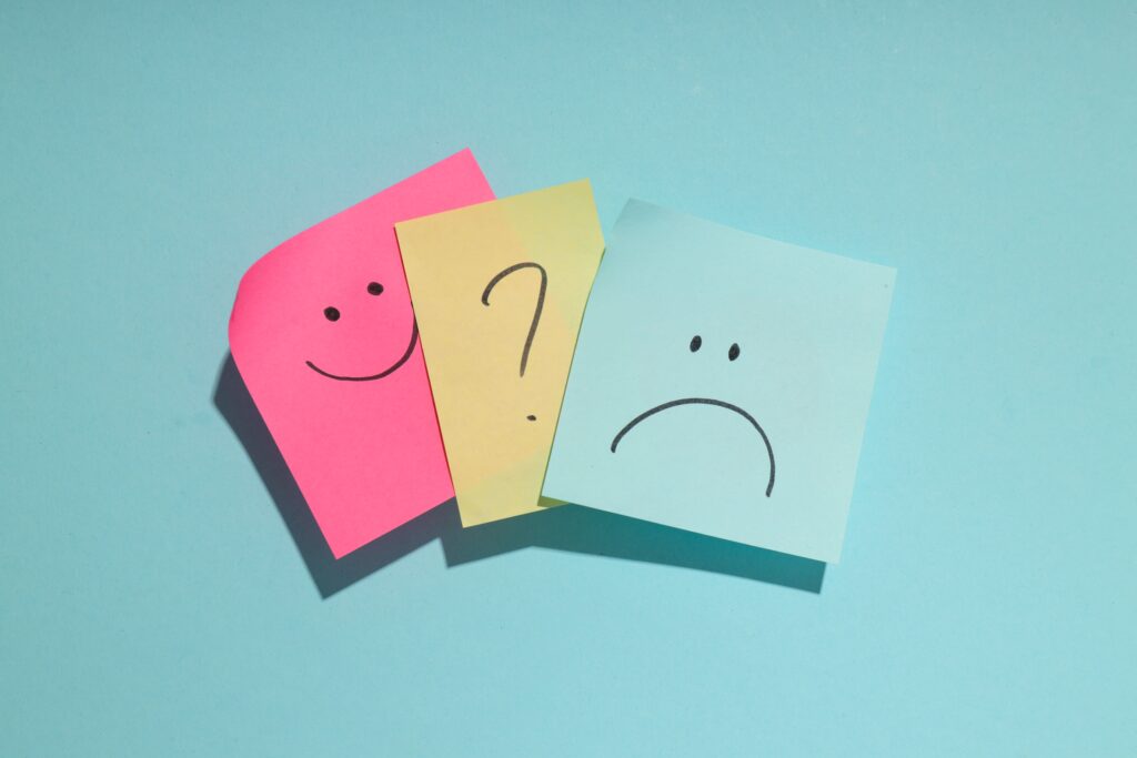 post-its com emoji feliz, interrogação e emoji triste representando dúvidas sobre riscos psicossociais no pgr.