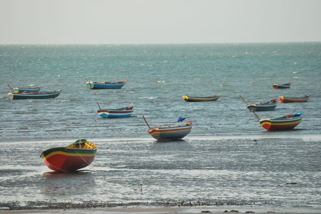 barcos de pesca coloridos ancorados na maré baixa em praia do piauí destino tranquilo no nordeste em julho.