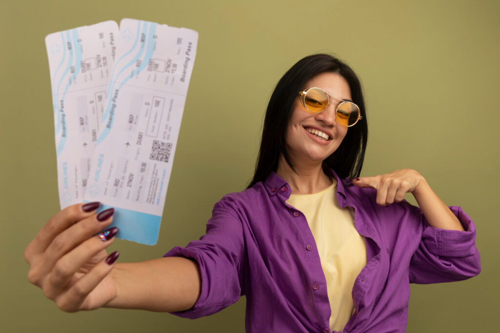Mulher morena sorridente com óculos de sol segurando vale-trabalho e vale-viagem