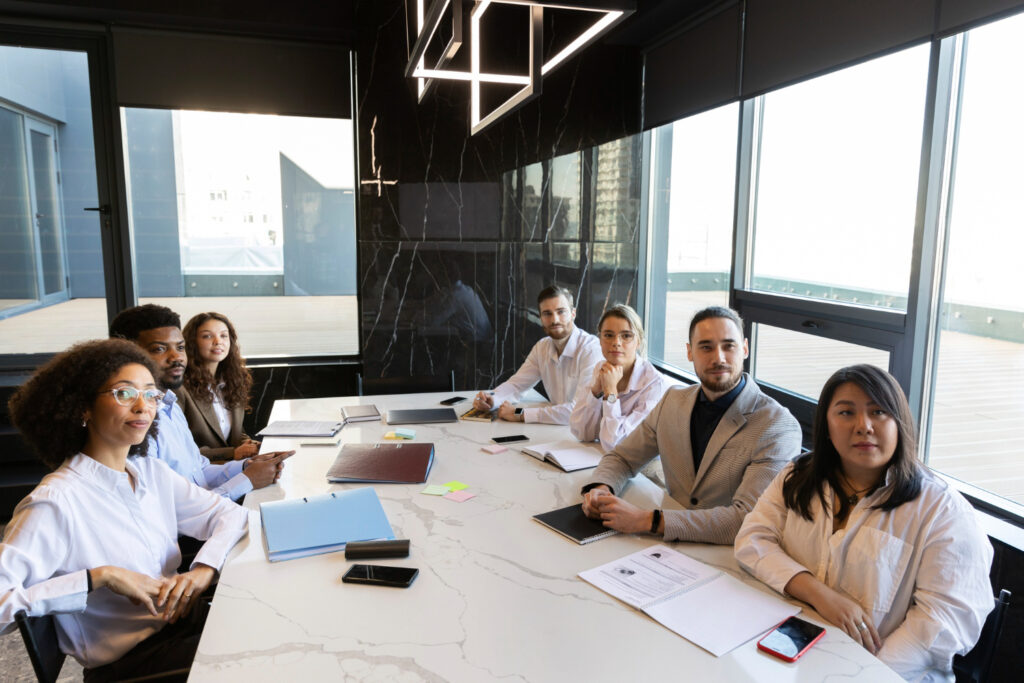 diretores encarando funcionário que propoe viagem como benefício
